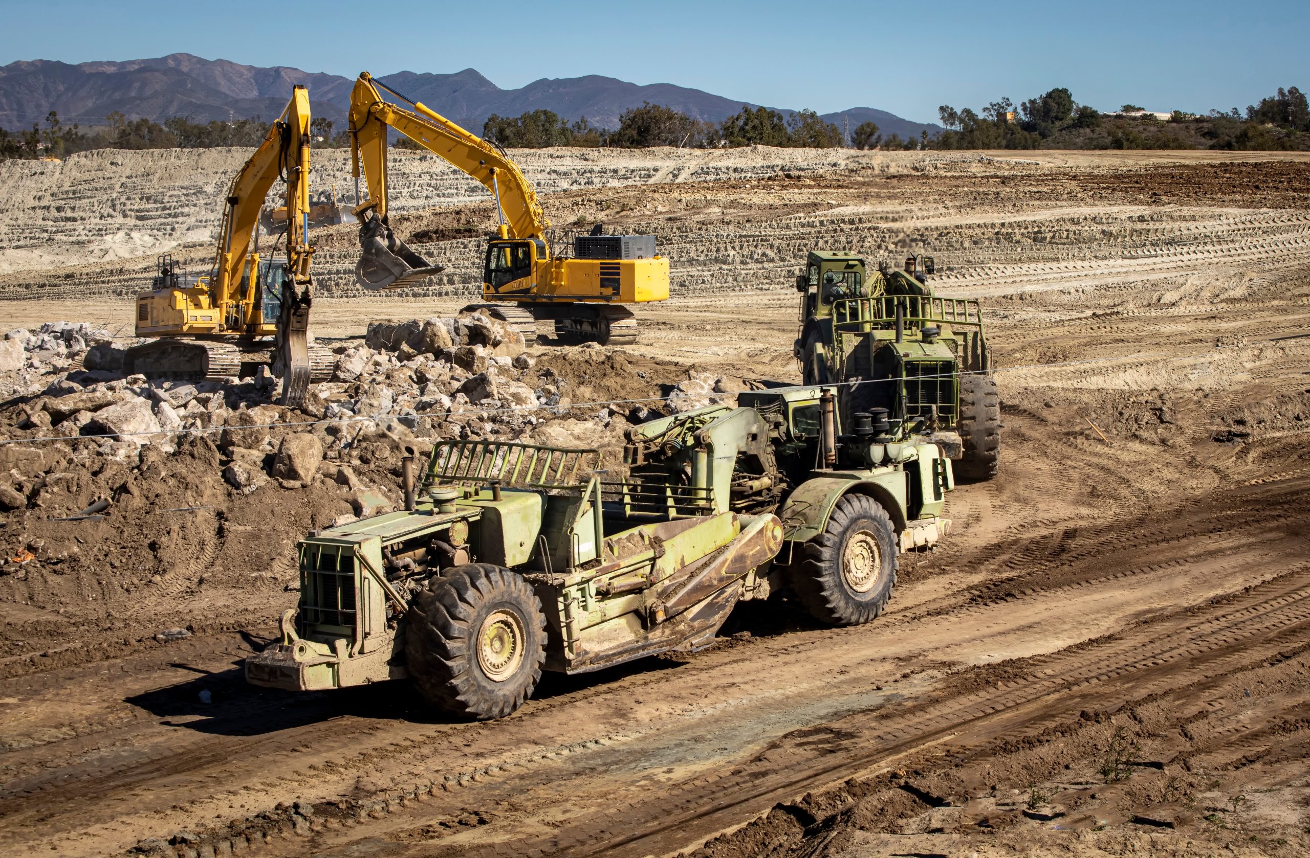 heavy-equipment-graders-and-bucket-cranes-on-a-con-2021-10-05-18-49-45-utc